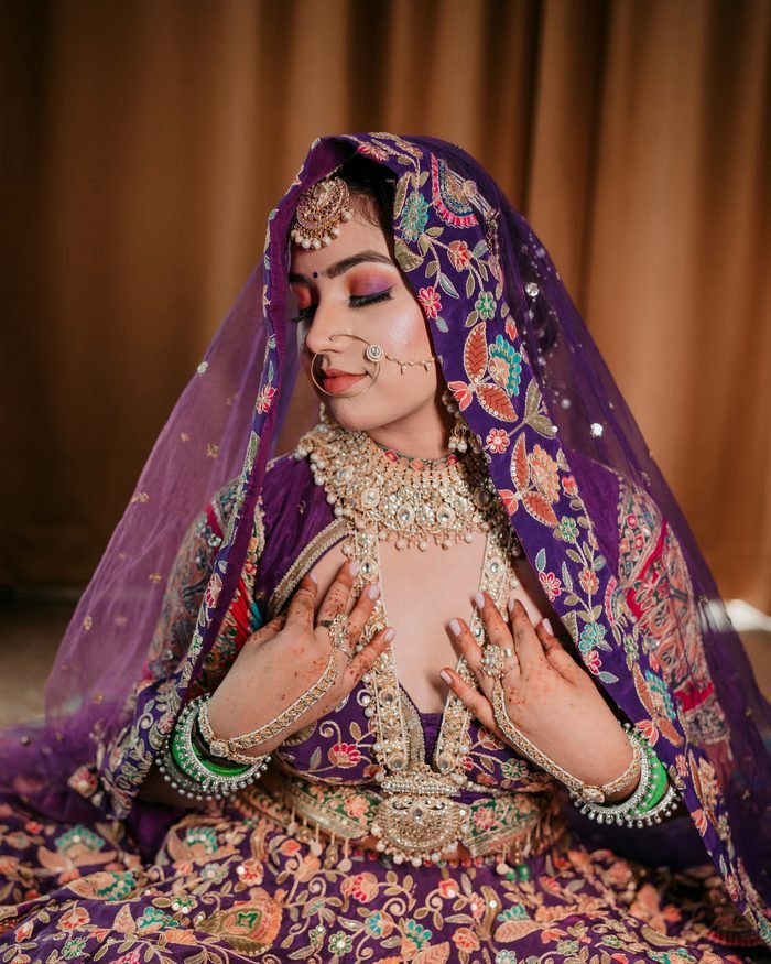 Bride in purple embroidered lehenga with kundan jewellery, makeup by THE HBM